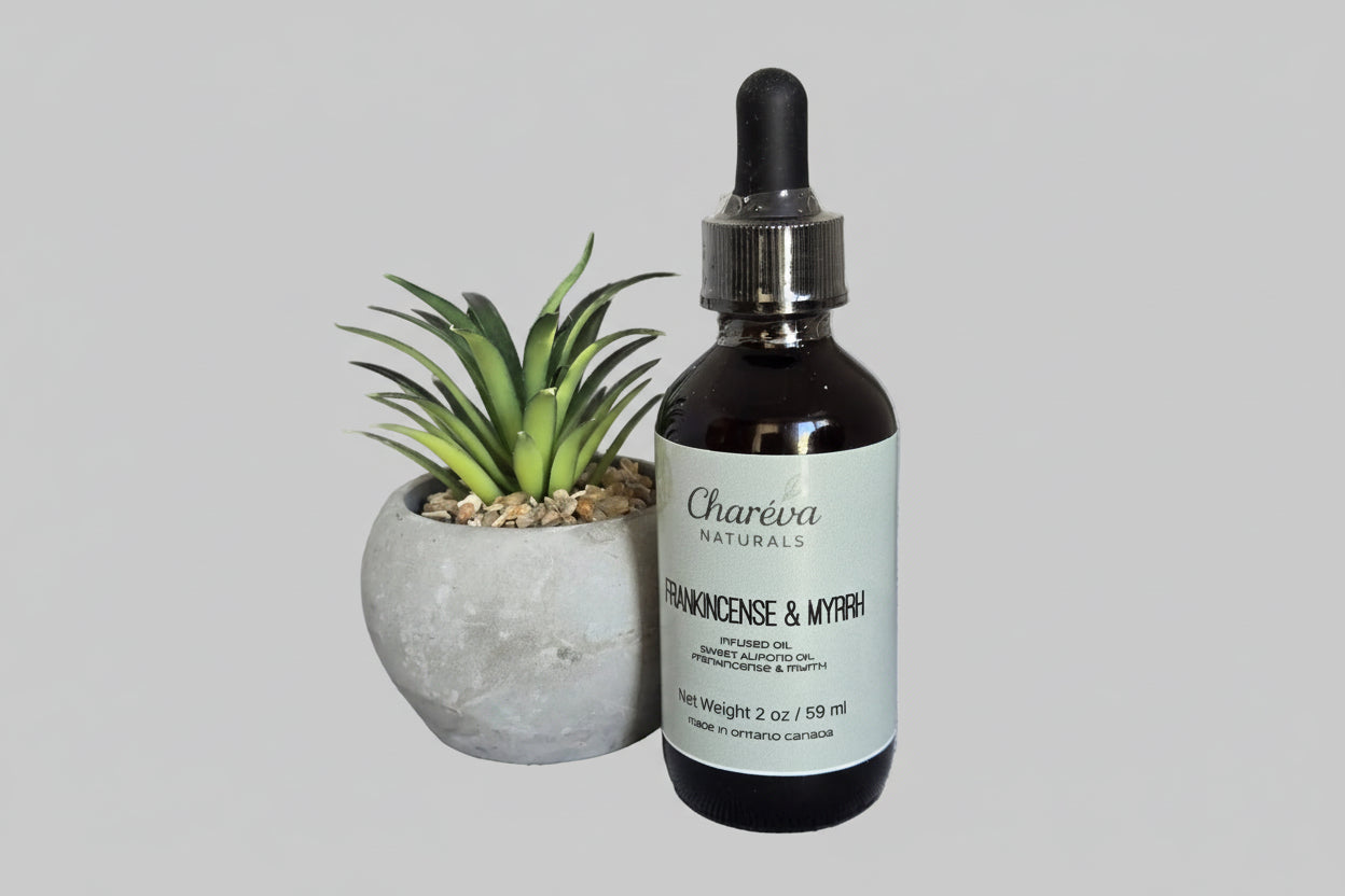 Bottle of Charéva Naturals Frankincense & Myrrh oil with a plant on a gray background